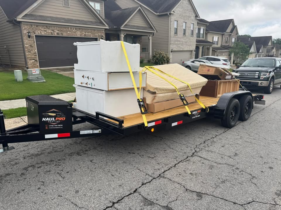 Haul Pro Hauling trailer loaded with a dresser, mattress, and boxes for junk removal